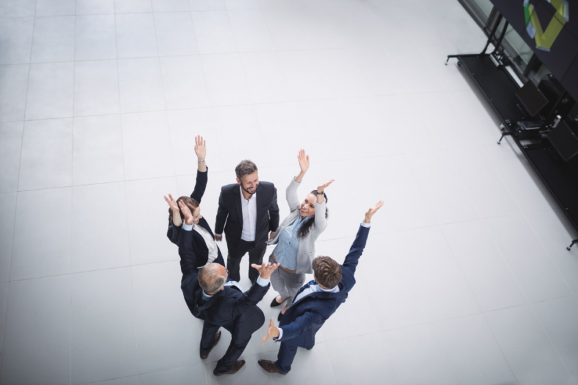 businesspeople-standing-with-hands-raised